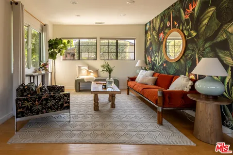 a living room with furniture a clock and a large window