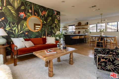 a living room with furniture a rug and a kitchen