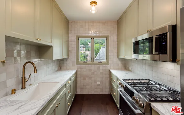 a kitchen with stainless steel appliances granite countertop a sink stove and cabinets