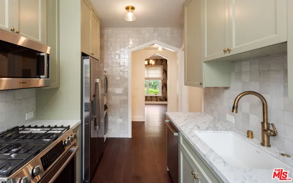 a kitchen with stainless steel appliances granite countertop a stove a sink and a microwave