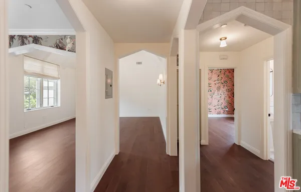 a view of a hallway with wooden floor and a bathroom
