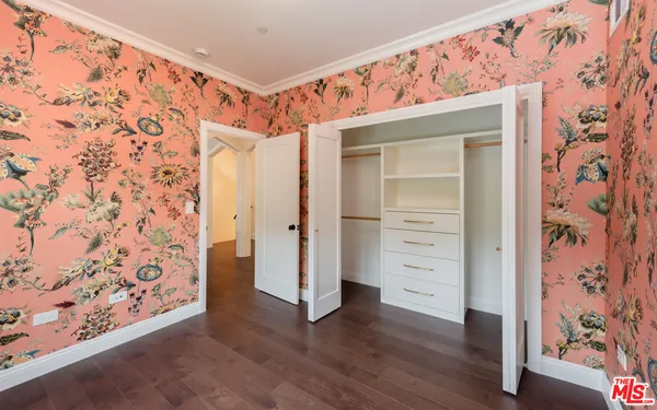 a view of a hallway with wooden floor and closet