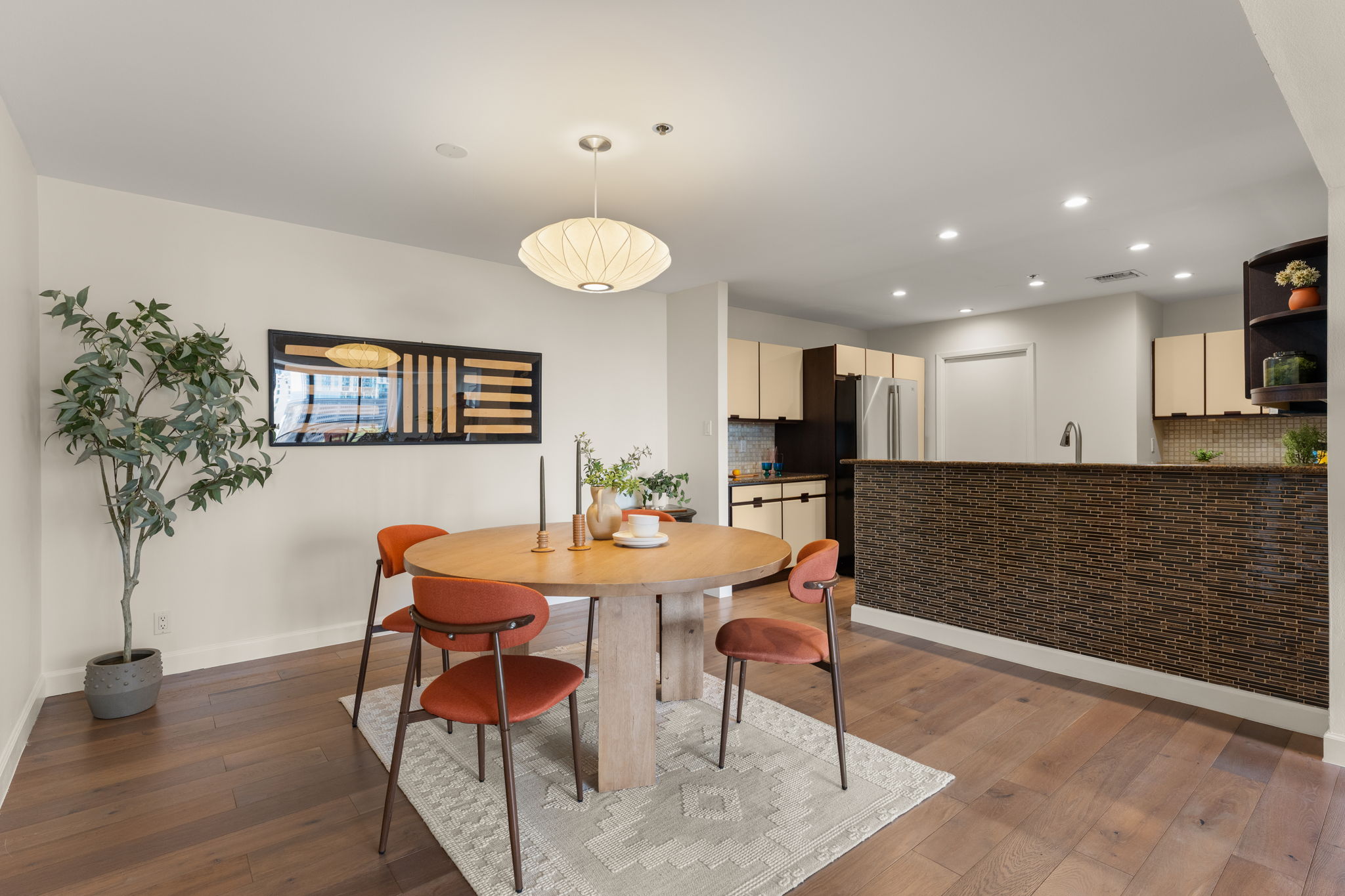 40 North Interstate Highway 35, Unit 11B2 Austin, TX 78701 - Photo 7 of 28 Hardwood floors stretch across this open-concept kitchen and dining area, accented by modern lighting.