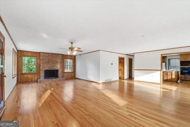 a view of an empty room with glass door and wooden floor