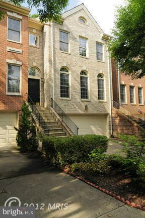 7841 Oracle Place Potomac, MD 20854 - Photo 11 of 29 a view of a white house with large windows next to a road