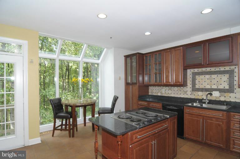 7841 Oracle Place Potomac, MD 20854 - Photo 26 of 29 a kitchen with granite countertop a stove a sink dishwasher and cabinets with wooden floor