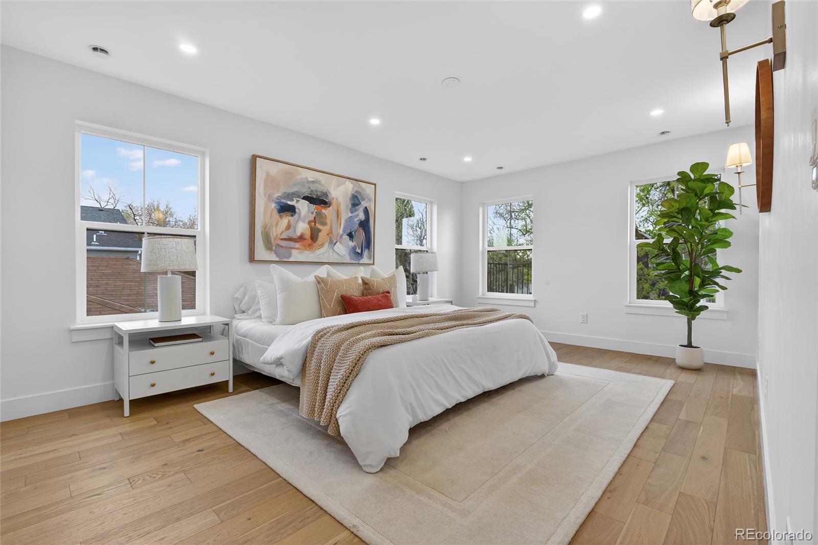 2362 South Acoma Street Denver, CO 80223 - Photo 22 of 50 a spacious bedroom with a large bed and a potted plant