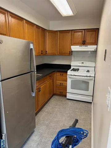 a kitchen with a refrigerator sink and cabinets
