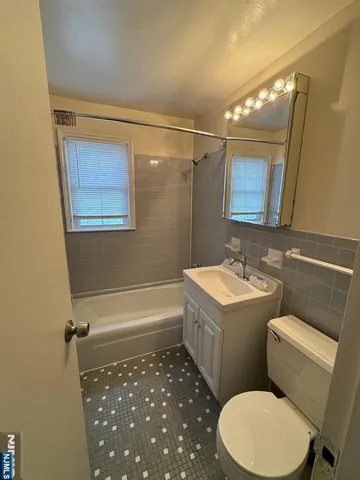 a bathroom with a sink a toilet a mirror and bathtub