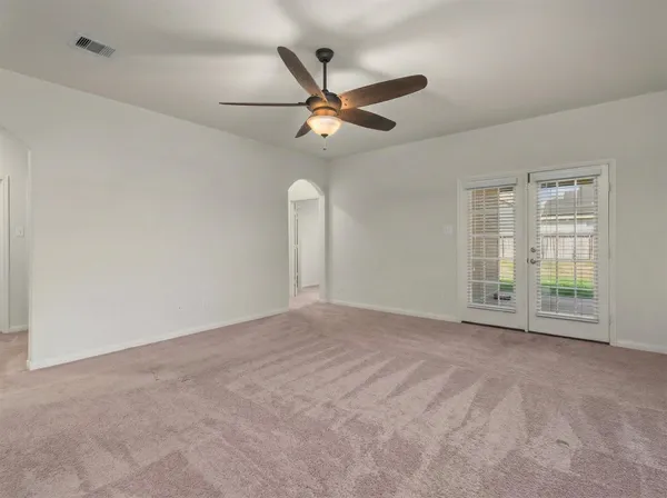 a view of an empty room with a ceiling fan