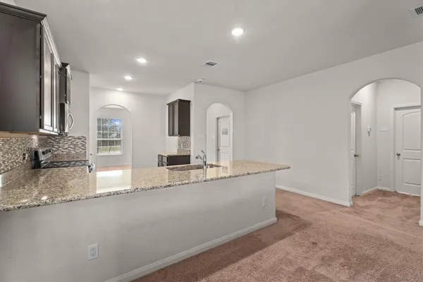a large kitchen with granite countertop a sink and a granite counter tops