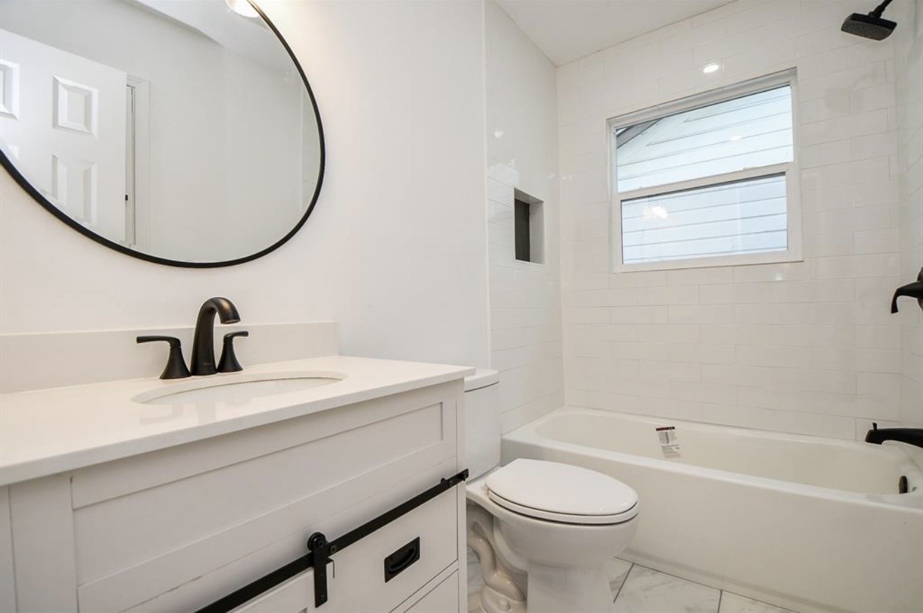 6834 St Augustine Street Houston, TX 77021 - Photo 14 of 21 a bathroom with a sink a toilet and a mirror