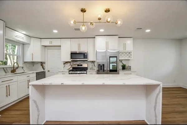 a large kitchen with kitchen island a sink stainless steel appliances and cabinets