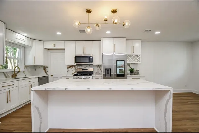 a large kitchen with kitchen island a sink stainless steel appliances and cabinets