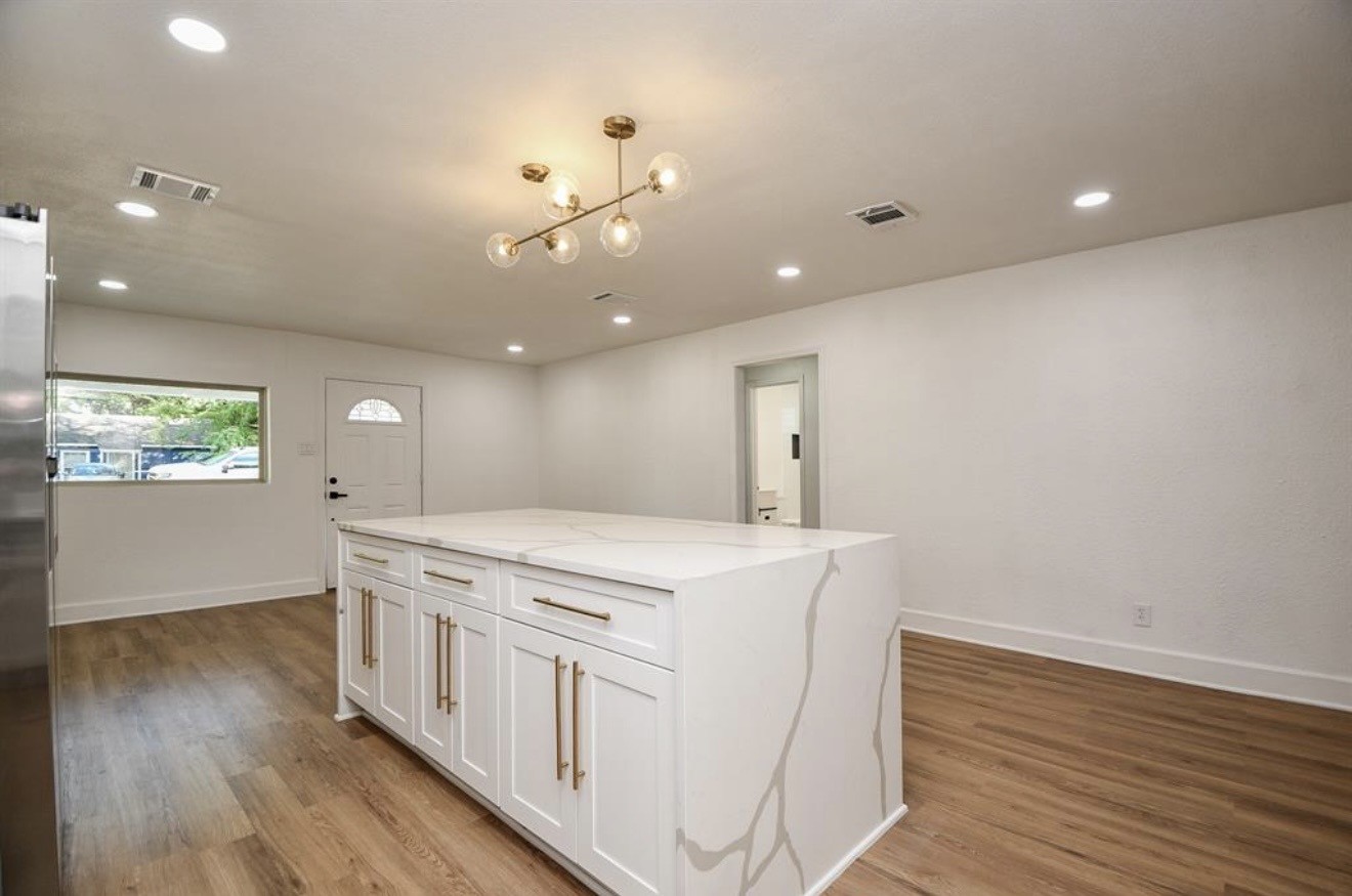 6834 St Augustine Street Houston, TX 77021 - Photo 5 of 21 a kitchen that has a microwave a stove and wooden floor