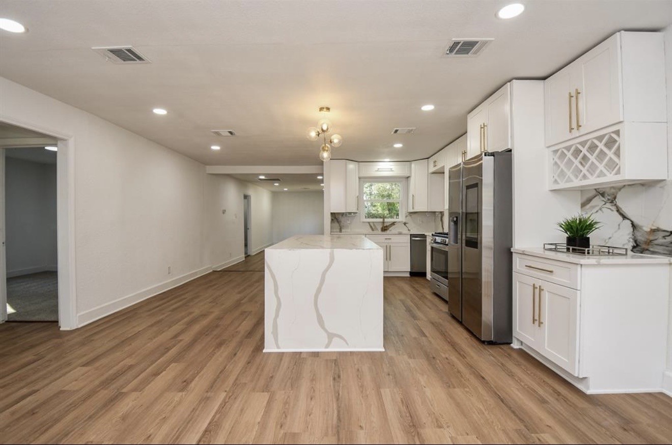 6834 St Augustine Street Houston, TX 77021 - Photo 6 of 21 a living room with stainless steel appliances furniture wooden floor and a view of kitchen