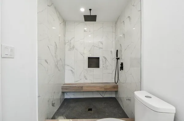 a bathroom with a toilet and a shower