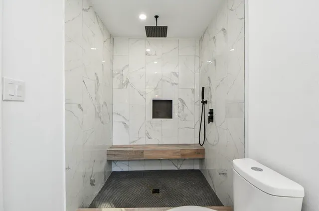 a bathroom with a toilet and a shower