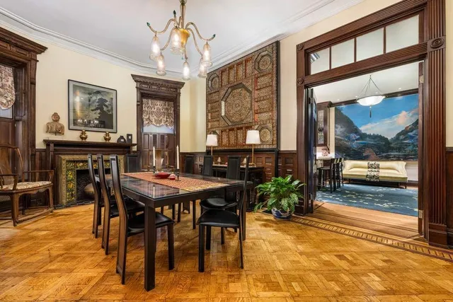a dining room with wooden floor a chandelier a wooden table and chairs