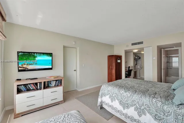 a bedroom with a bed and a flat screen tv