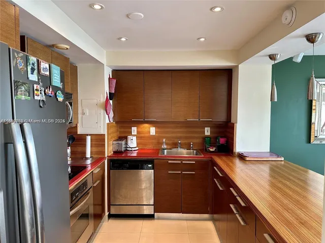 a kitchen with stainless steel appliances granite countertop a refrigerator and a sink