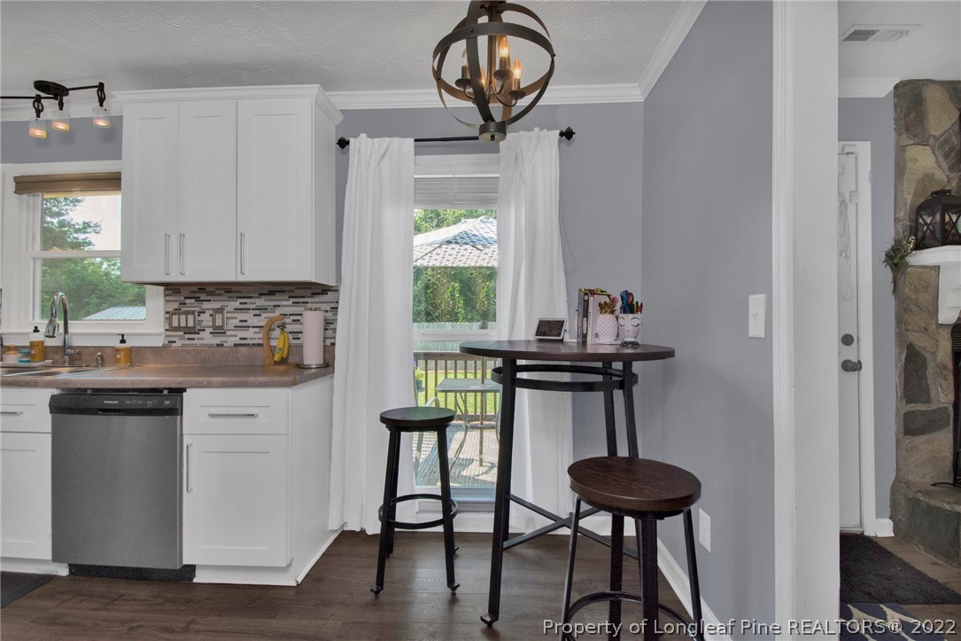 1021 Locks Creek Road Fayetteville, NC 28312 - Photo 11 of 34 a kitchen with stainless steel appliances a table chairs and a window