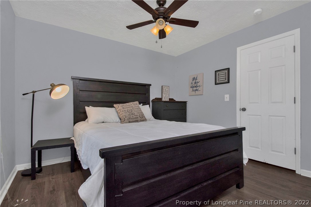1021 Locks Creek Road Fayetteville, NC 28312 - Photo 18 of 34 a bedroom with a bed and a chandelier