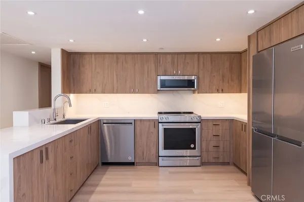 a kitchen with stainless steel appliances granite countertop a refrigerator sink and stove