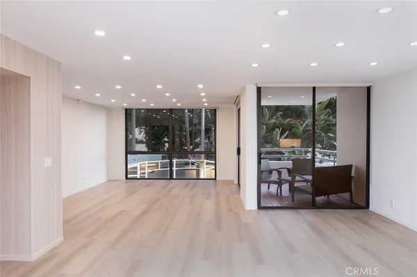 a view of a big room with large windows and furniture