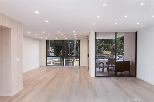 a view of a big room with large windows and furniture
