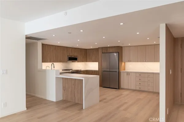 a kitchen with a stove a refrigerator and a sink