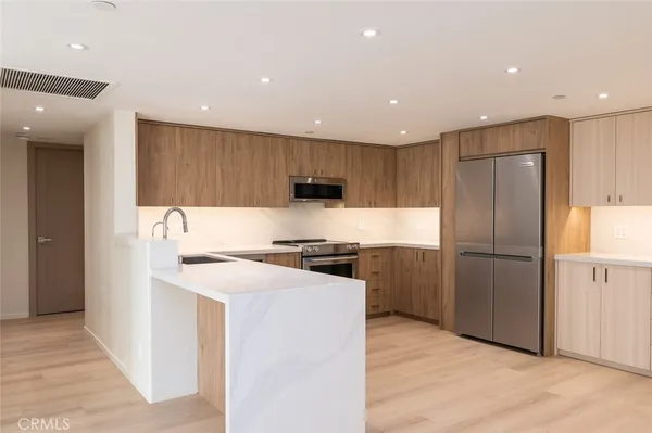 a kitchen with a refrigerator a stove top oven and a center island