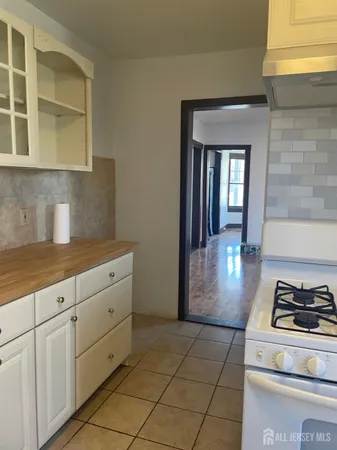 a kitchen with white cabinets and appliances