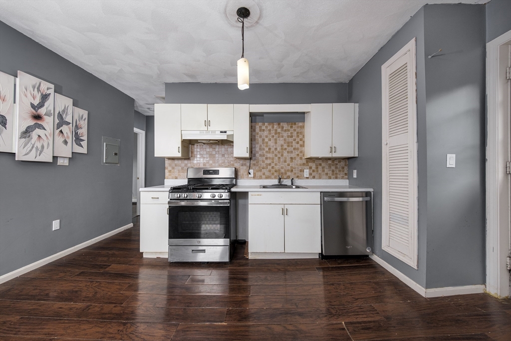 a kitchen with a white cabinets and window