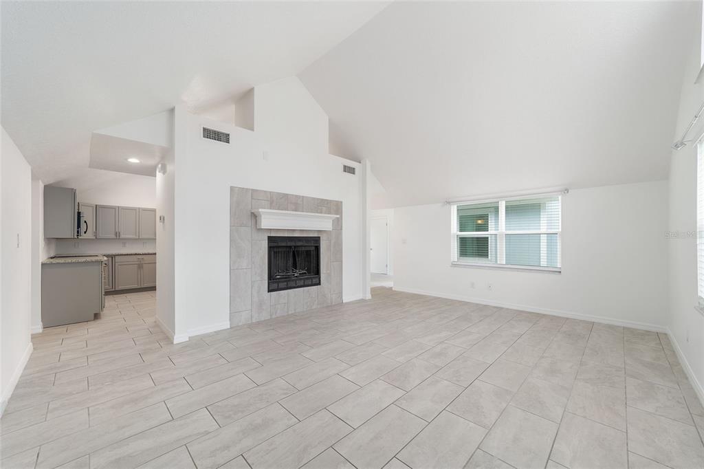2159 Southeast 7th Terrace Ocala, FL 34471 - Photo 13 of 59 an empty room with kitchen view and a fireplace