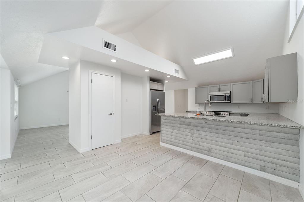 2159 Southeast 7th Terrace Ocala, FL 34471 - Photo 16 of 59 a view of a kitchen with kitchen island granite countertop living room and fireplace