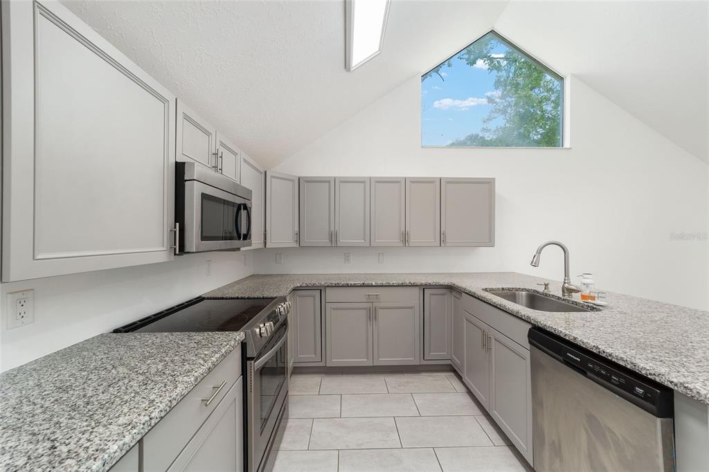 2159 Southeast 7th Terrace Ocala, FL 34471 - Photo 21 of 59 a kitchen with stainless steel appliances granite countertop a sink and a stove top oven with granite countertops