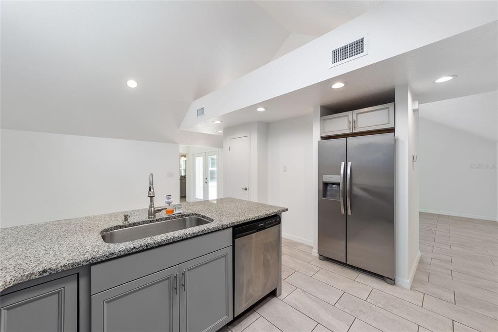 2159 Southeast 7th Terrace Ocala, FL 34471 - Photo 22 of 59 a bathroom with a granite countertop sink a large mirror and a refrigerator
