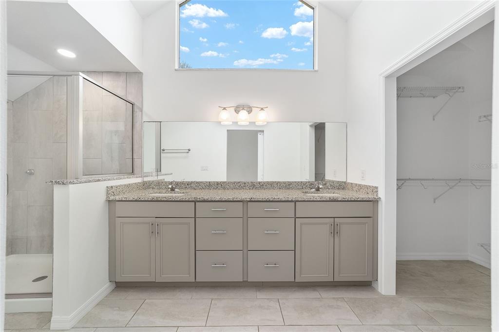 2159 Southeast 7th Terrace Ocala, FL 34471 - Photo 26 of 59 a bathroom with a granite countertop sink a mirror and a bathtub
