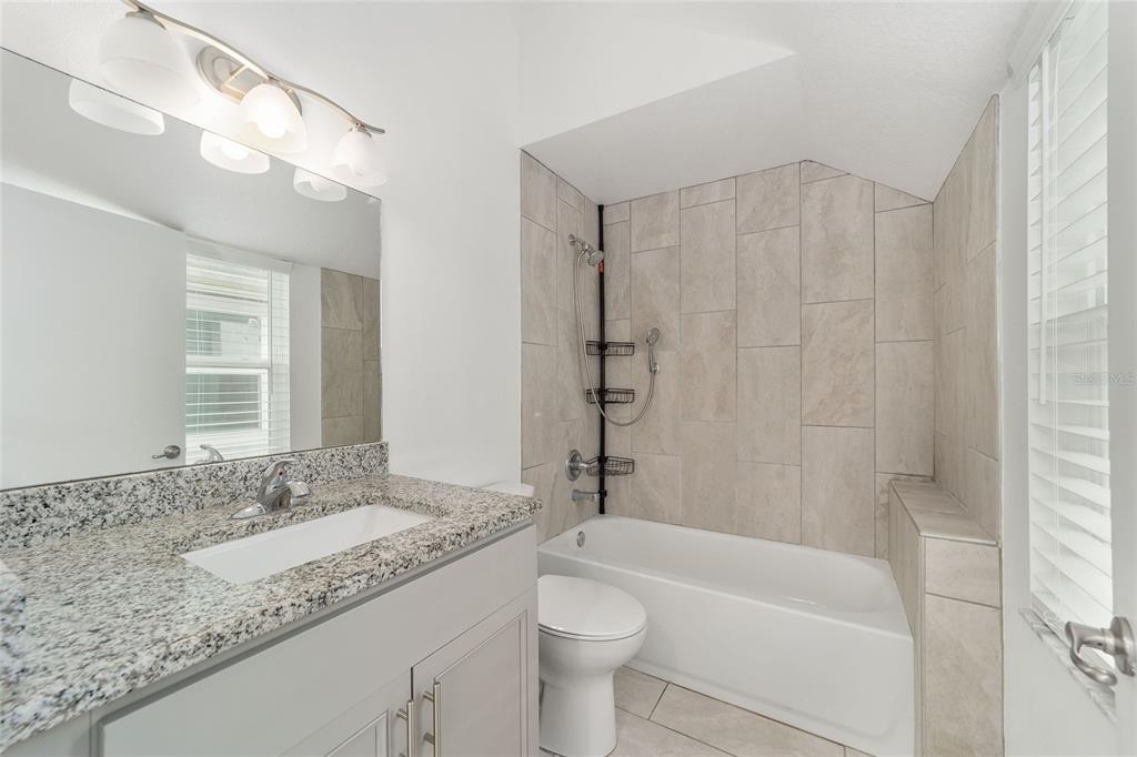 2159 Southeast 7th Terrace Ocala, FL 34471 - Photo 32 of 59 a bathroom with a granite countertop sink a toilet and bathtub