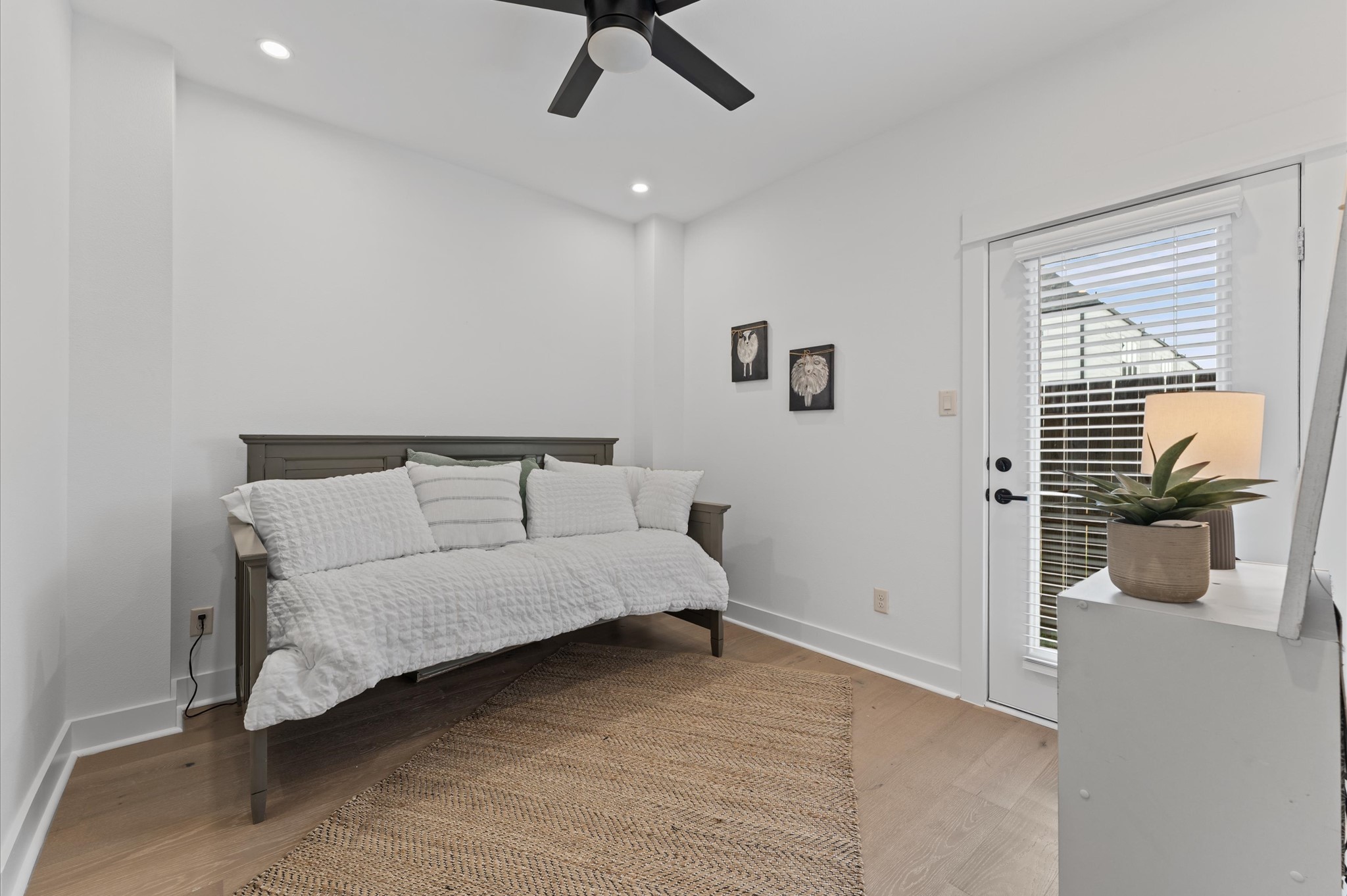 3002 Jensen Drive Houston, TX 77026 - Photo 23 of 42 Stylish and versatile secondary bedroom situated on the first floor, offering direct access to the backyard through elegant glass patio door. This sunlit space features warm-toned flooring, soft neutral walls, and generous room for a queen-sized bed and additional furnishings. Outdoor access enhances the room’s appeal for relaxation, remote work, guest room.
