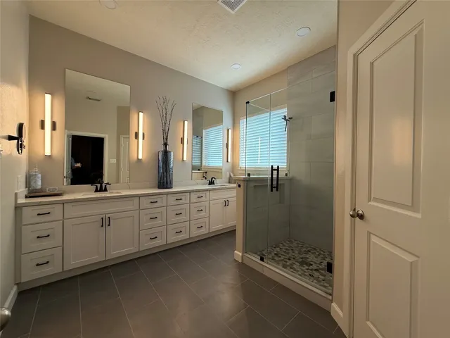 a spacious bathroom with double sink and shower