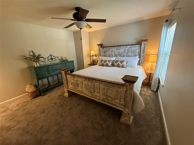 a bedroom with a bed and a chandelier fan