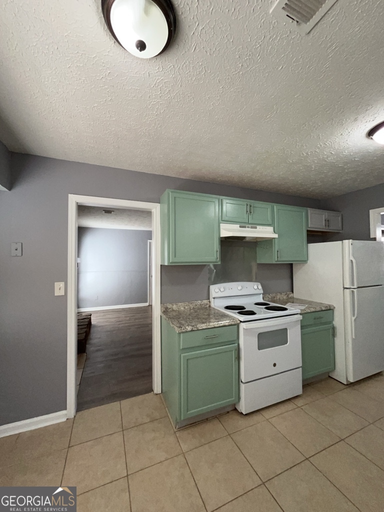 1682 Charmeth Road Lithonia, GA 30058 - Photo 11 of 52 a kitchen with a stove top oven and cabinets