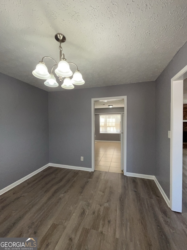 1682 Charmeth Road Lithonia, GA 30058 - Photo 13 of 52 wooden floor in an empty room with a window