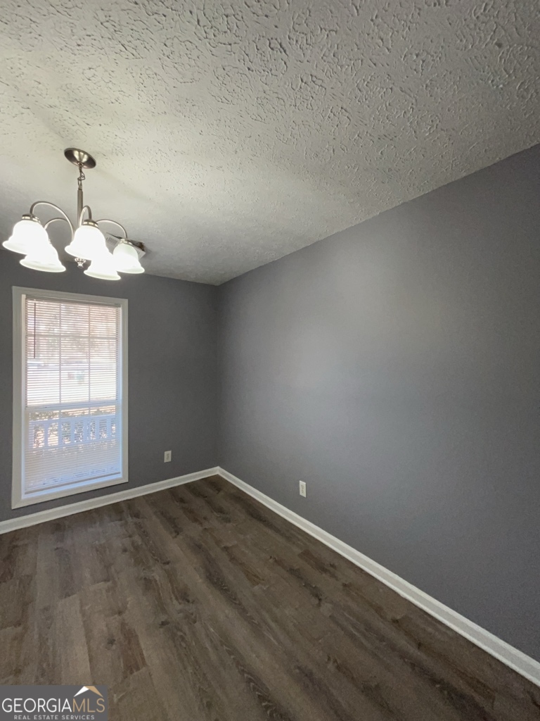 1682 Charmeth Road Lithonia, GA 30058 - Photo 14 of 52 an empty room with wooden floor and windows