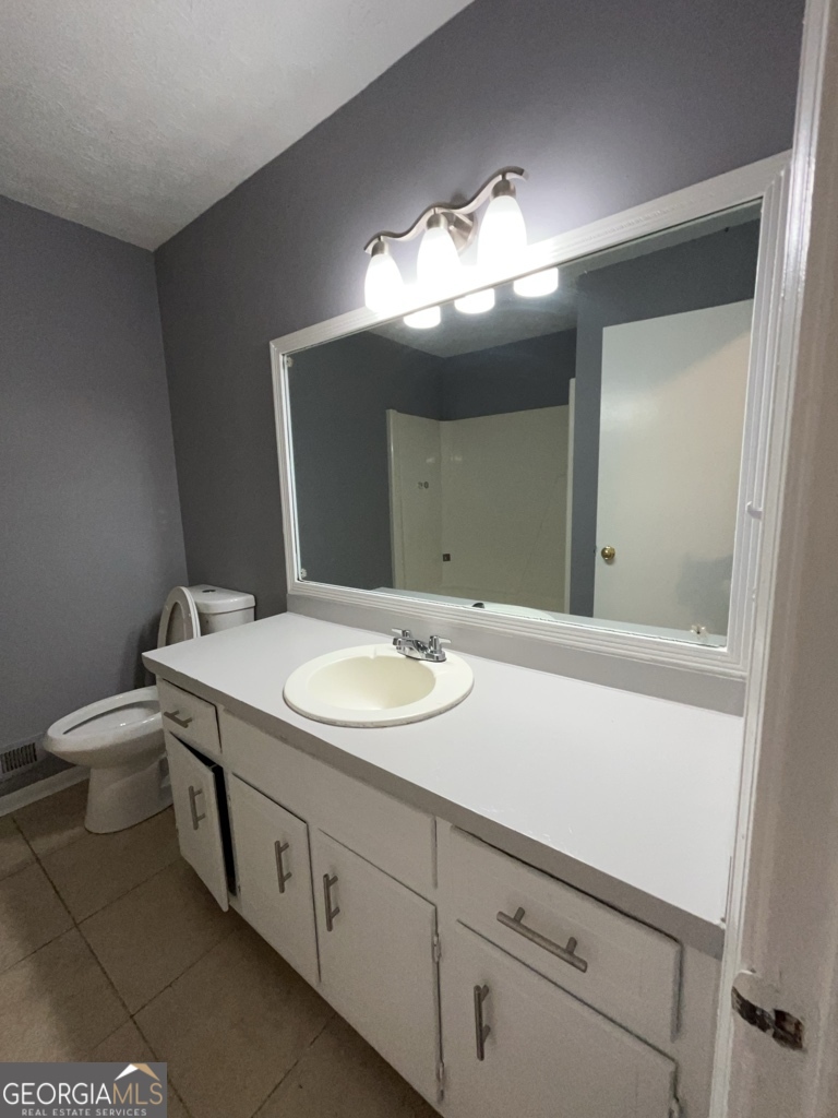1682 Charmeth Road Lithonia, GA 30058 - Photo 27 of 52 a bathroom with a toilet sink and mirror