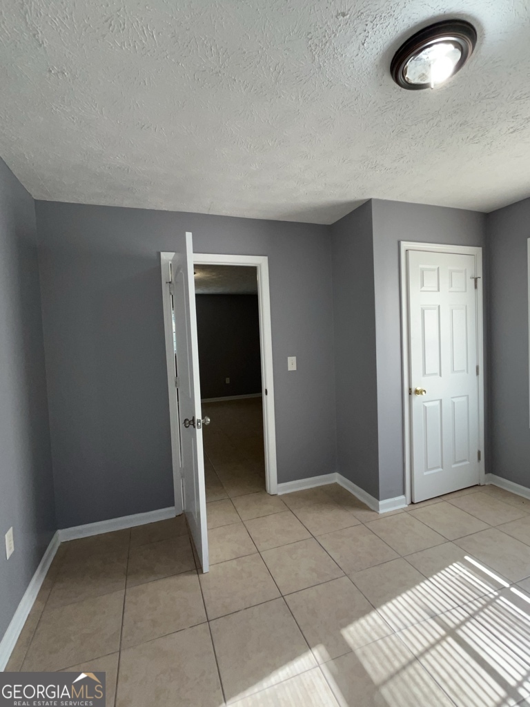1682 Charmeth Road Lithonia, GA 30058 - Photo 43 of 52 an empty room with kitchen and entrance