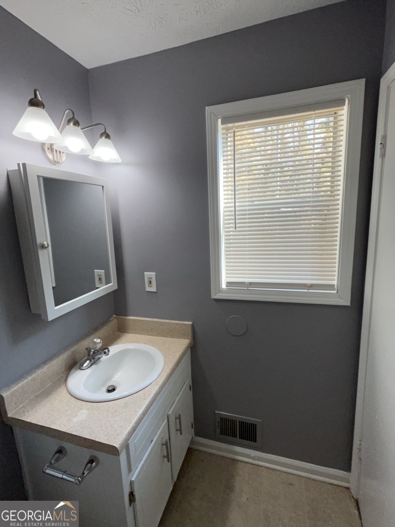 1682 Charmeth Road Lithonia, GA 30058 - Photo 45 of 52 a bathroom with a sink and a mirror