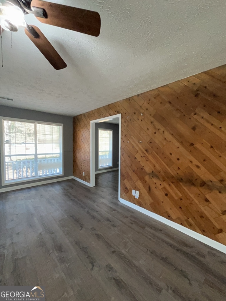 1682 Charmeth Road Lithonia, GA 30058 - Photo 7 of 52 an empty room with wooden floor and windows